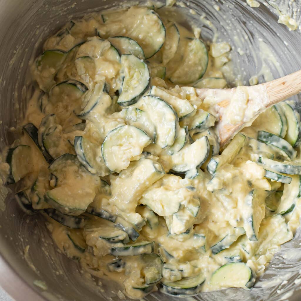 zucchini mixed with cheese in a mixing bowl