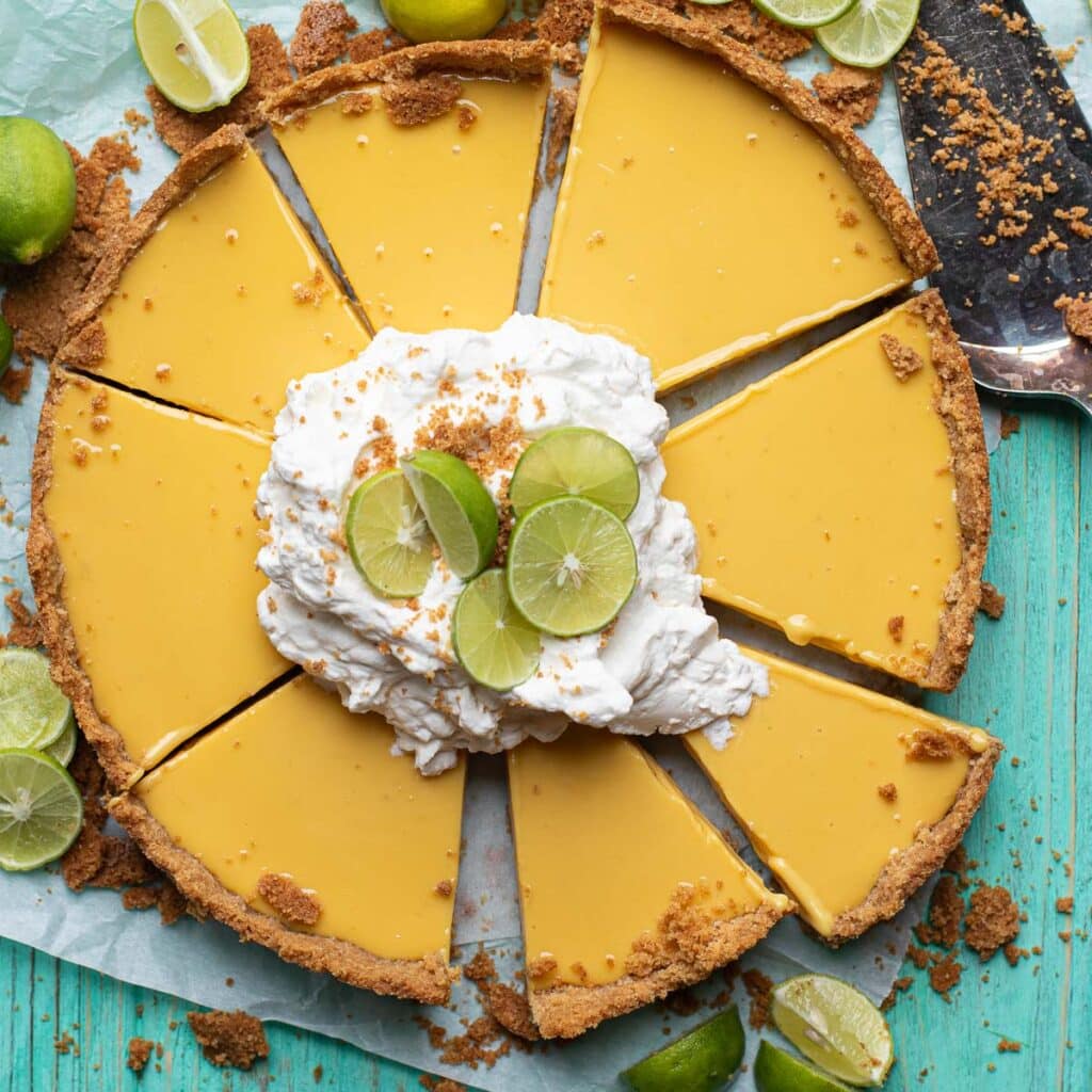 key west key lime pie topped with whipped cream and lime wedges