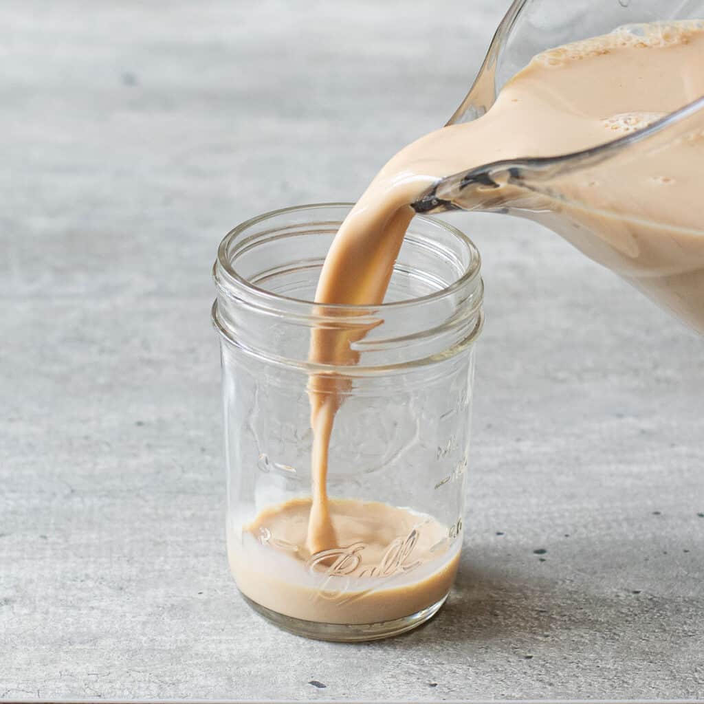 coffee jello mixture being poured into a mason jar