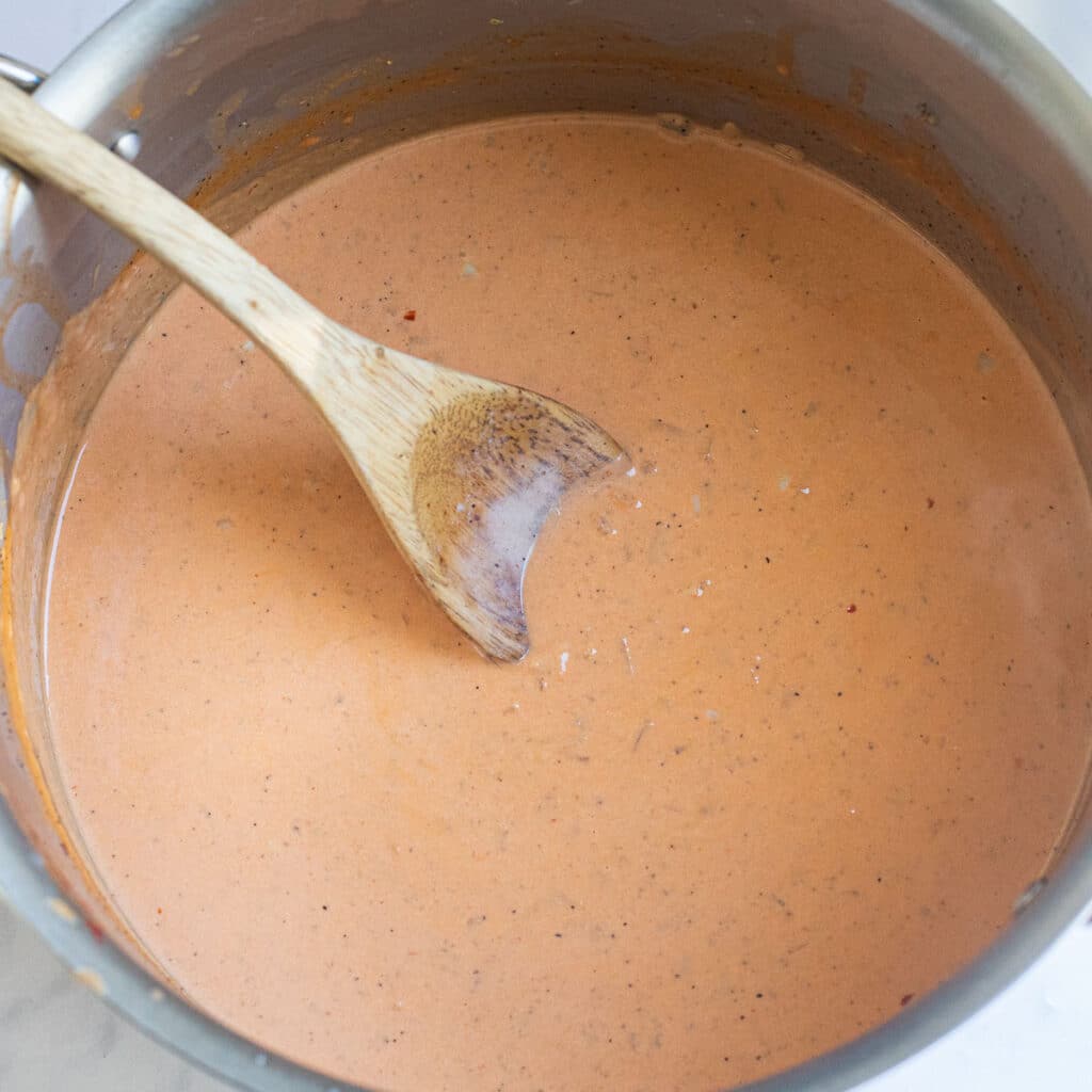 blush sauce cooking in a stainless steel pan