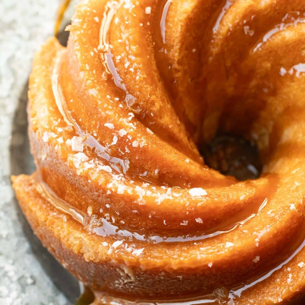 close up view of flaky sea salt on top of a salted caramel Kentucky butter cake