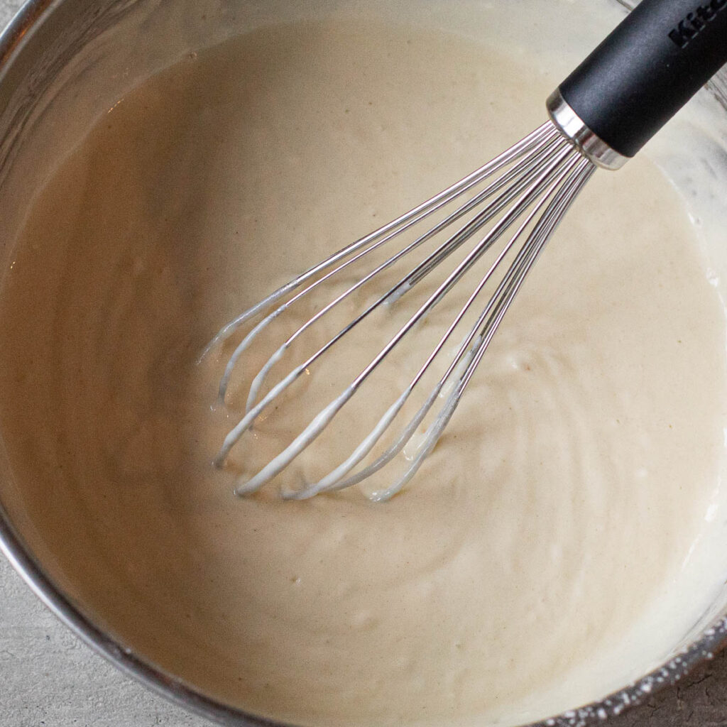 pancake batter being whisked in a mixing bowl