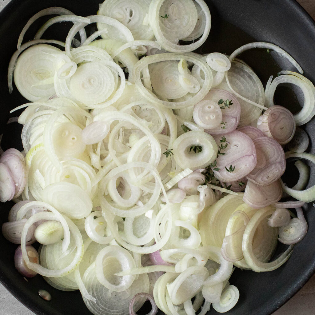 sliced onions and shallots in a large skillet