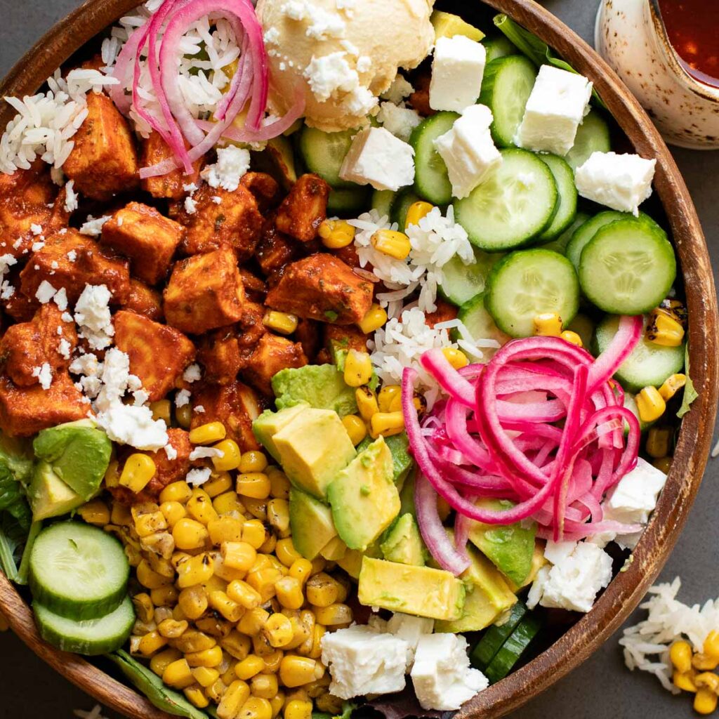 harissa chicken cava bowl with cucumbers, avocado, pickled onions and feta cheese