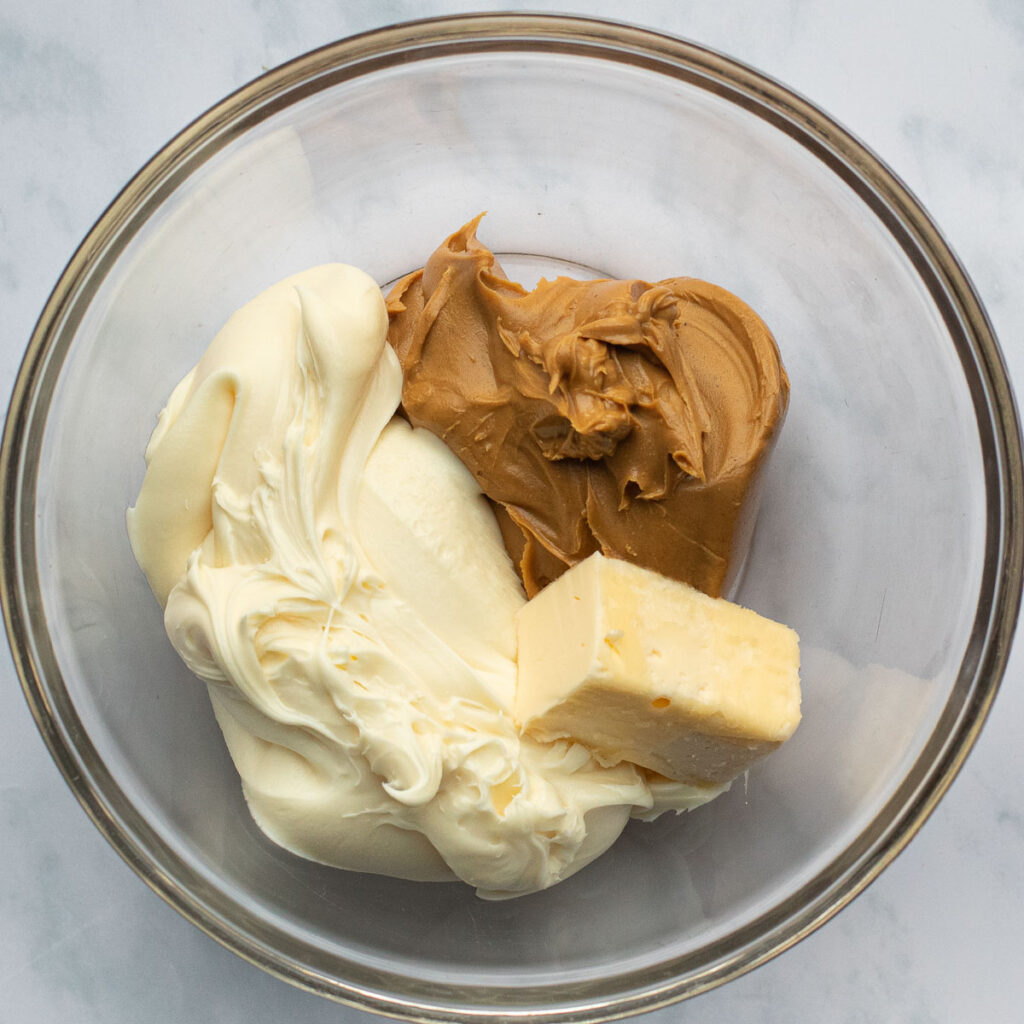 peanut butter, butter and vanilla frosting in a glass mixing bowl