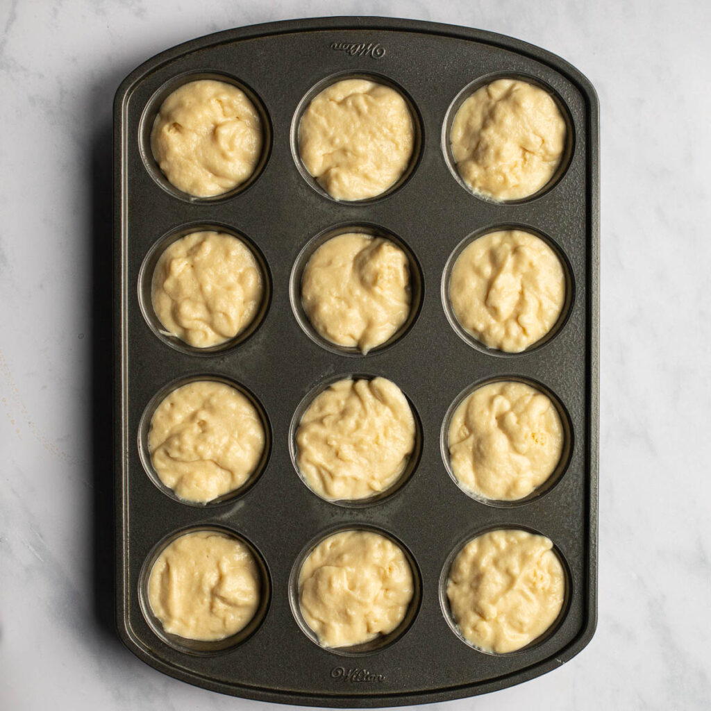 Champagne cupcake batter in a muffin tin before baking