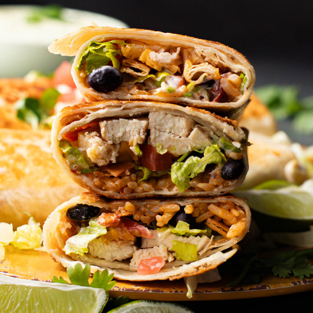 chipotle ranch grilled chicken burritos in a stack of three 