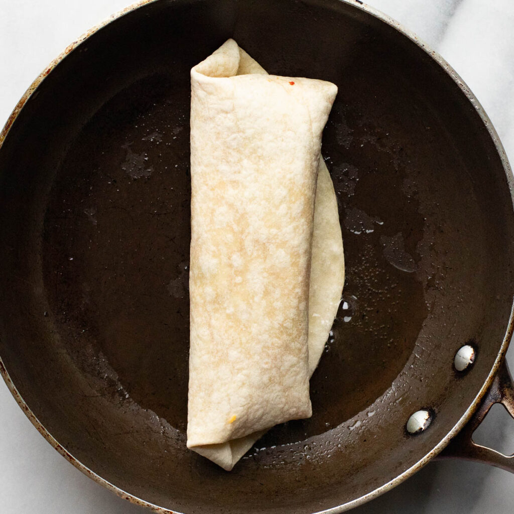 a burrito cooking in a pan