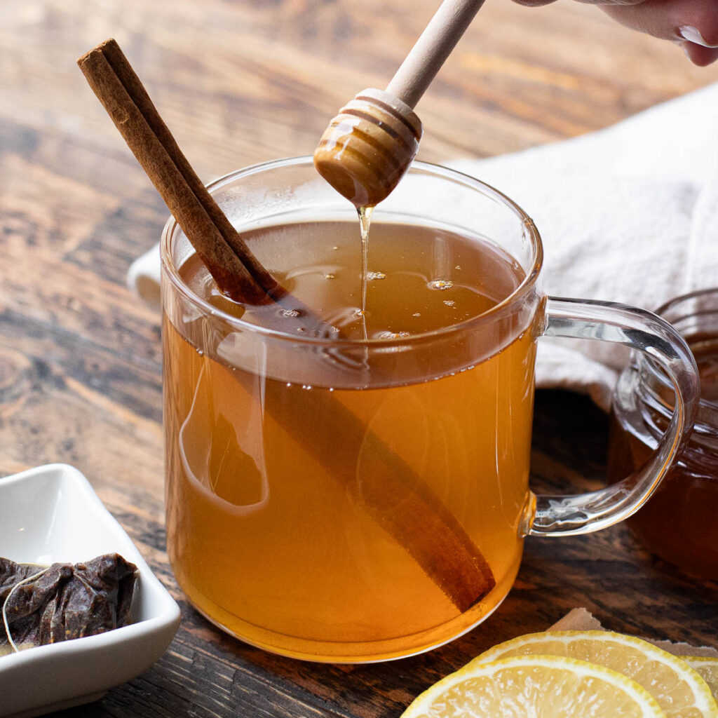 honey being drizzled into a hot toddy 