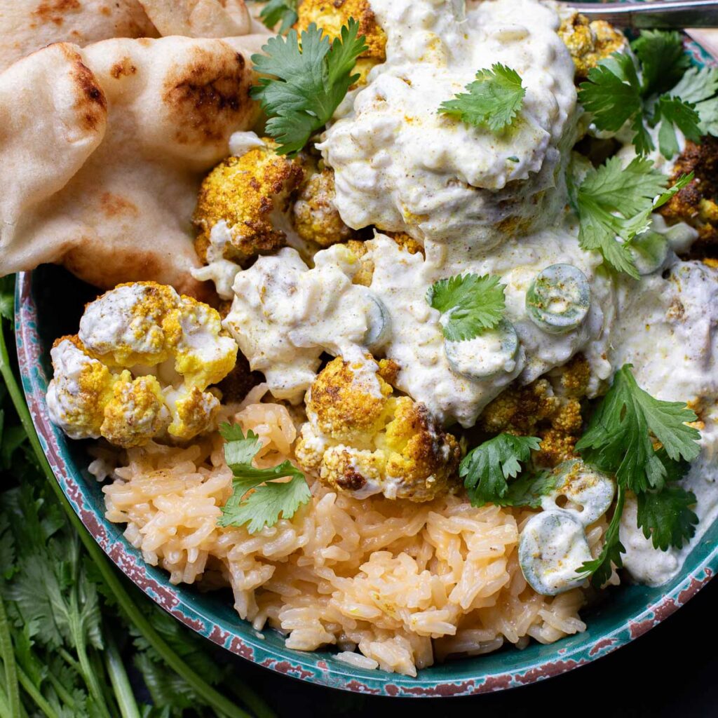 Indian cauliflower curry over coconut rice with naan