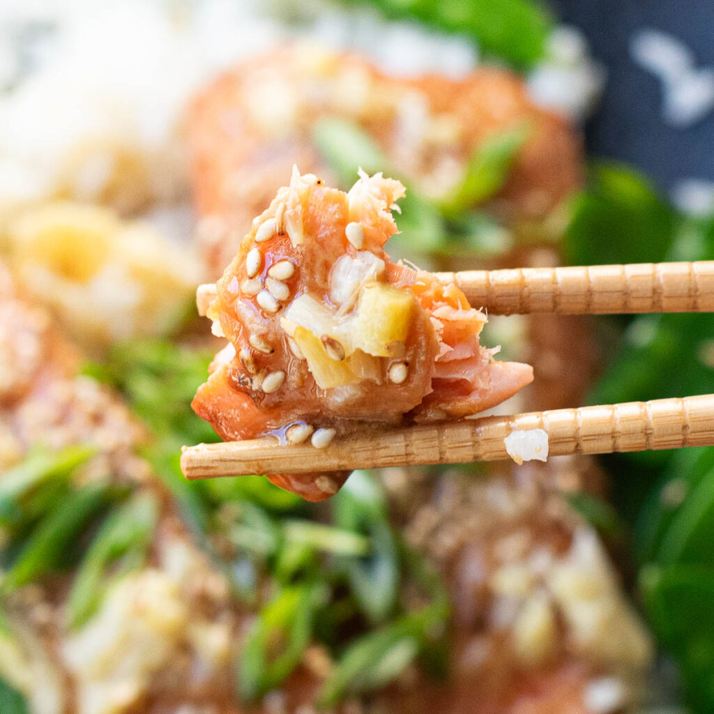 chopsticks holding a piece of miso salmon