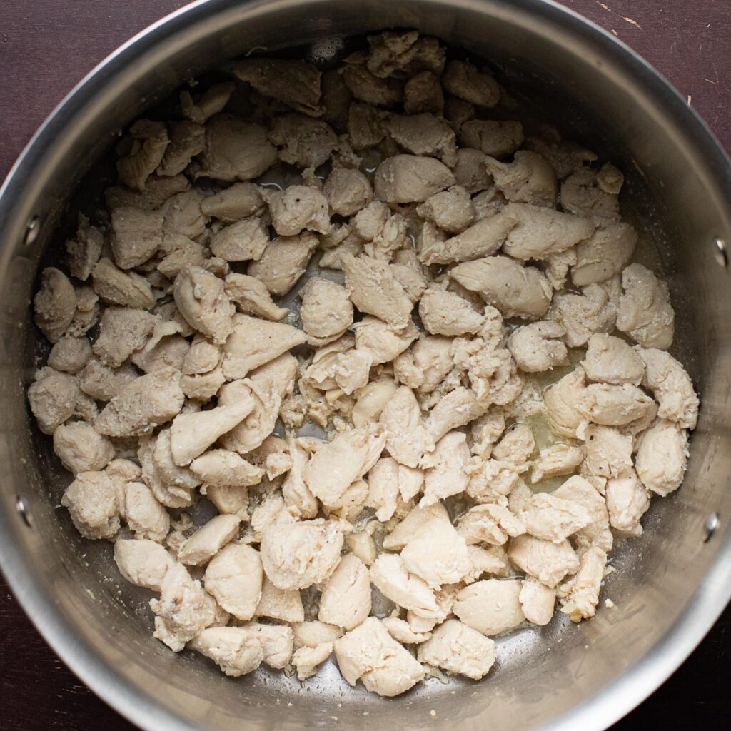 chunks of chicken cooking in a pot