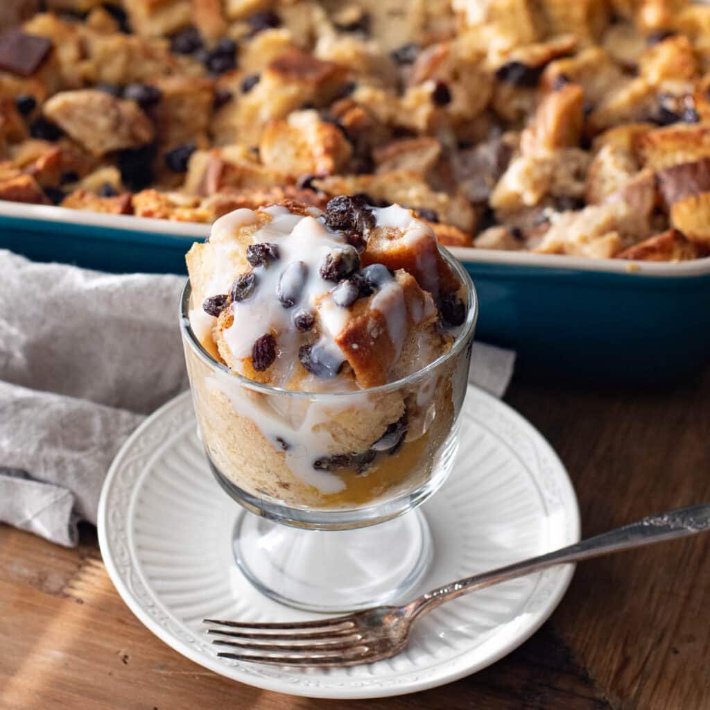 New Orleans bread pudding with buttered rum sauce in a glass dish with raisins