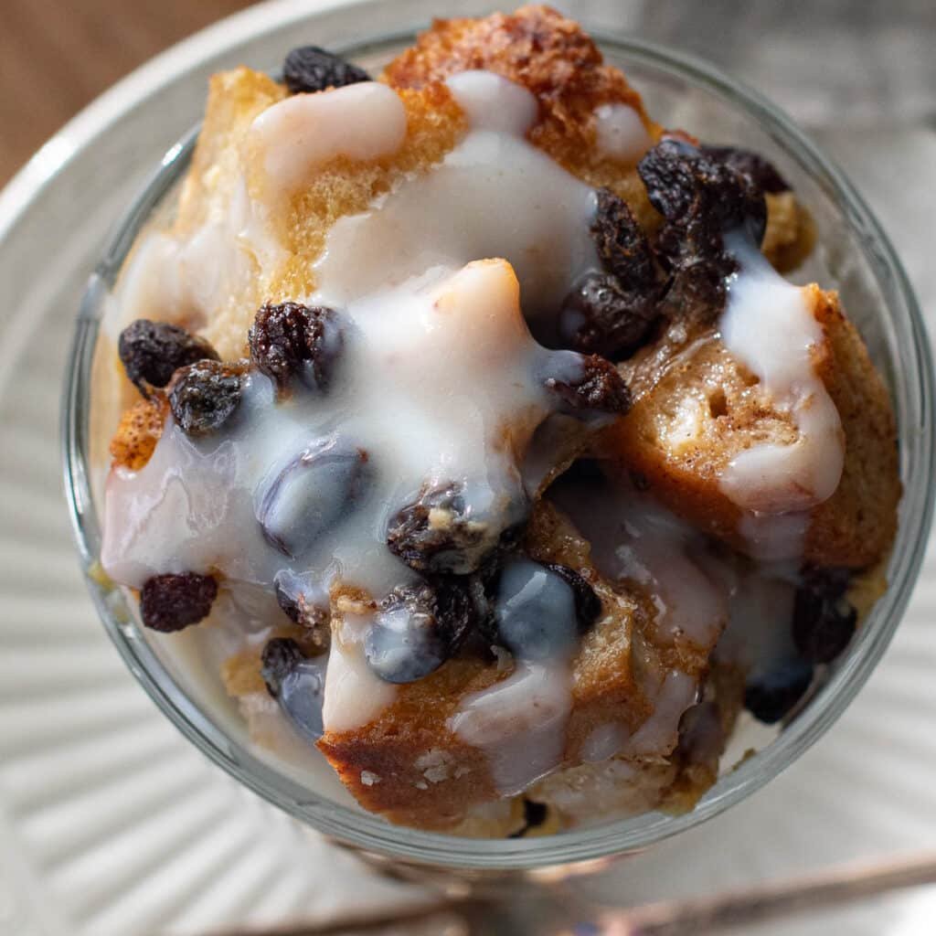 overhead view of Louisiana bread pudding topped with rum sauce and raisins