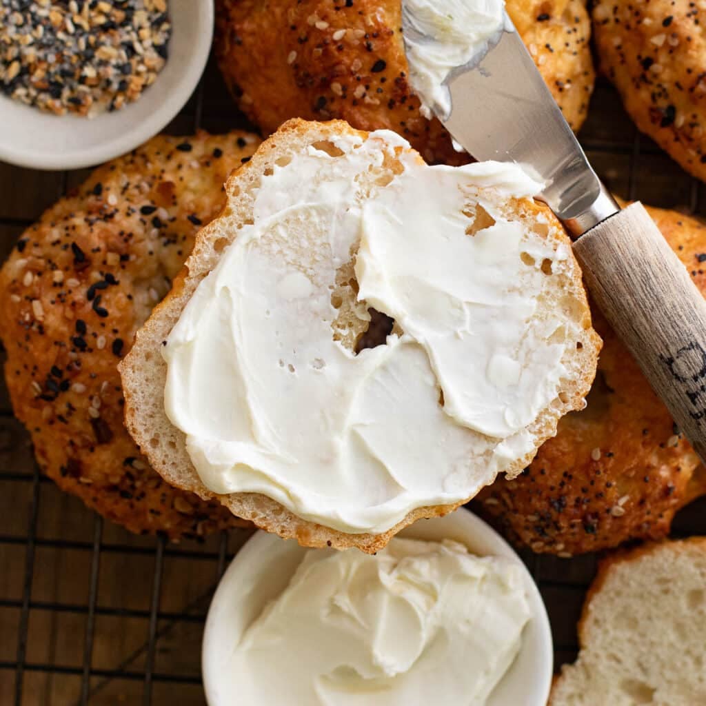 a half a cottage cheese bagel smeared with cream cheese