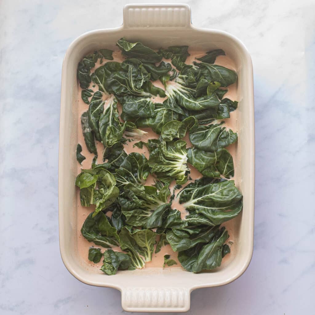 bok choy leaves arranged in a baking dish