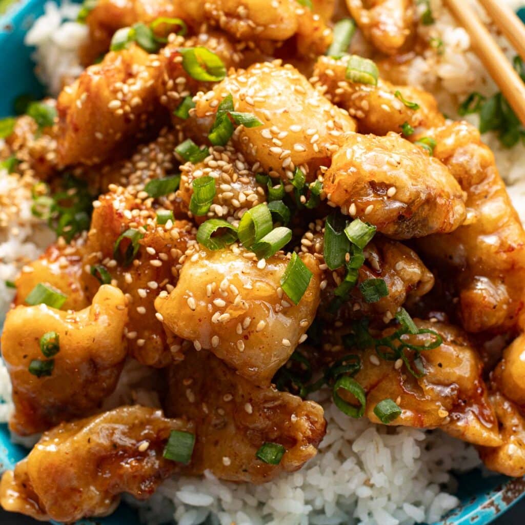 honey butter chicken topped with chopped green onions and sesame seeds