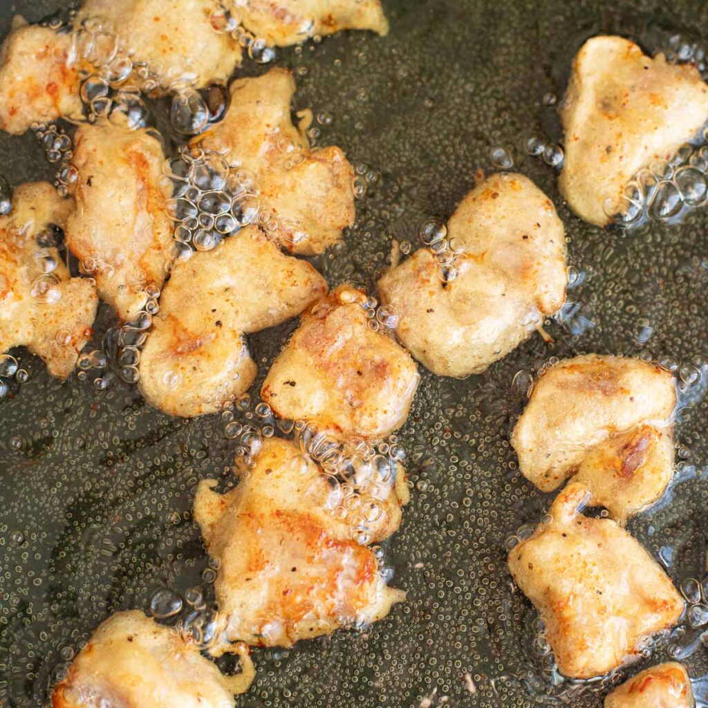 chicken pieces frying in oil