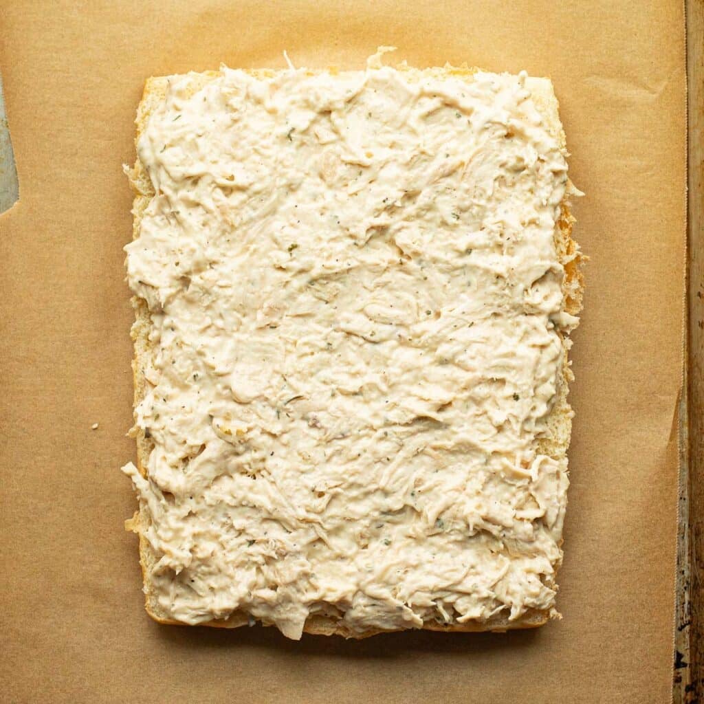 shredded chicken spread over the bottom half of slider buns