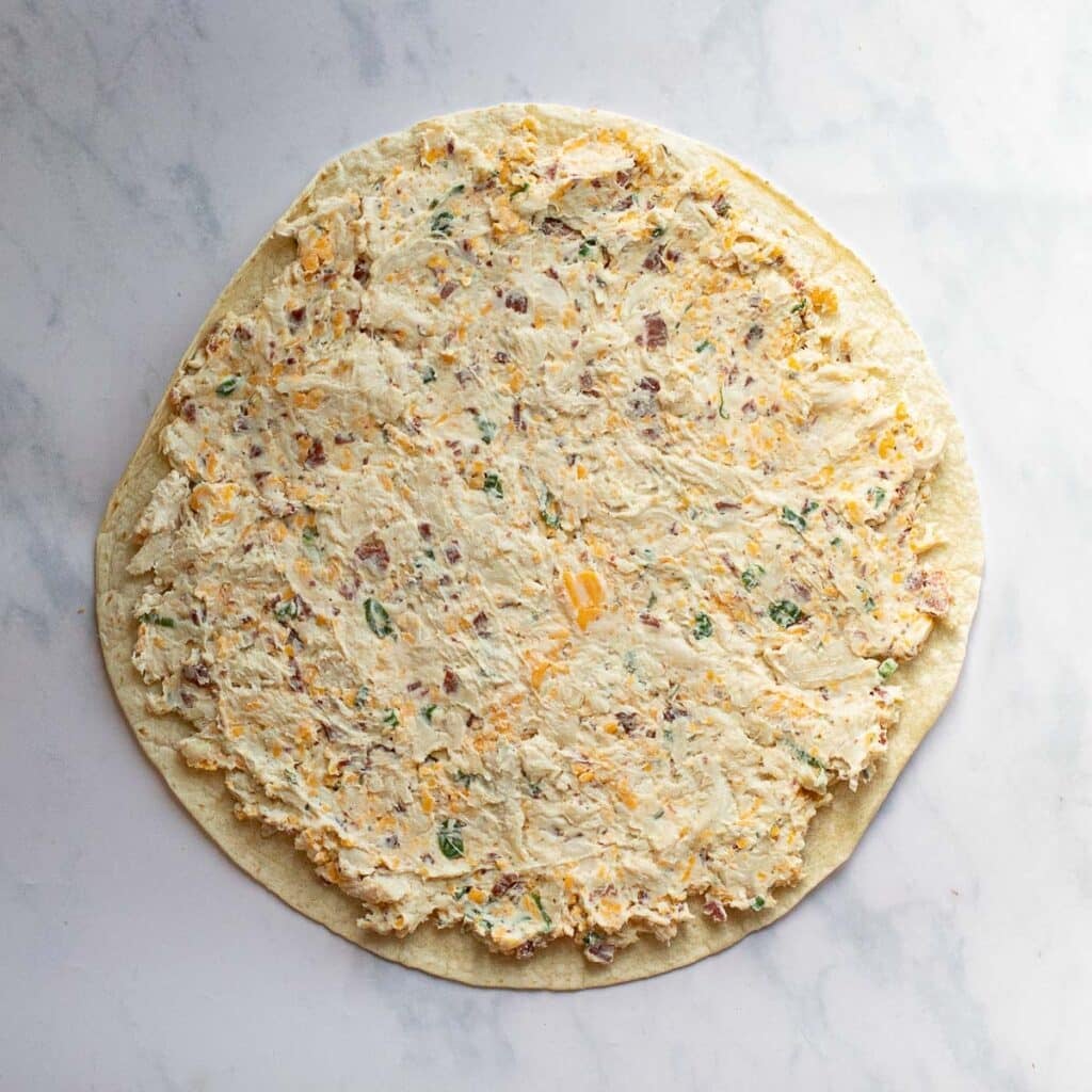 chicken mixture spread onto a flour tortilla