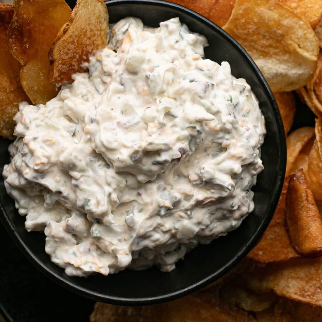 viral dill pickle dip in a black bowl