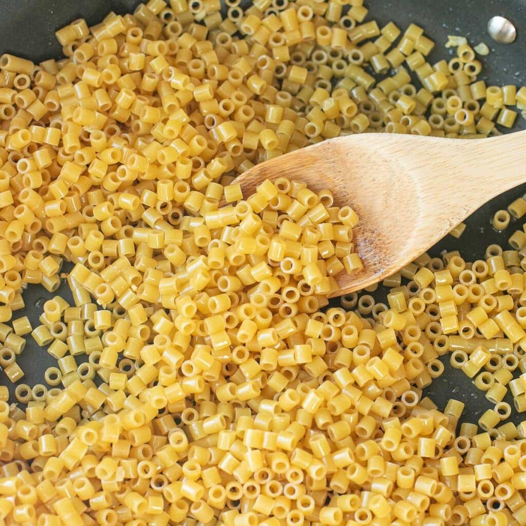 ditalini pasta tossed in olive oil in a pan