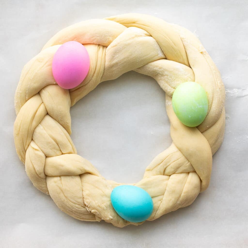 unbaked ring of Easter bread topped with colored eggs