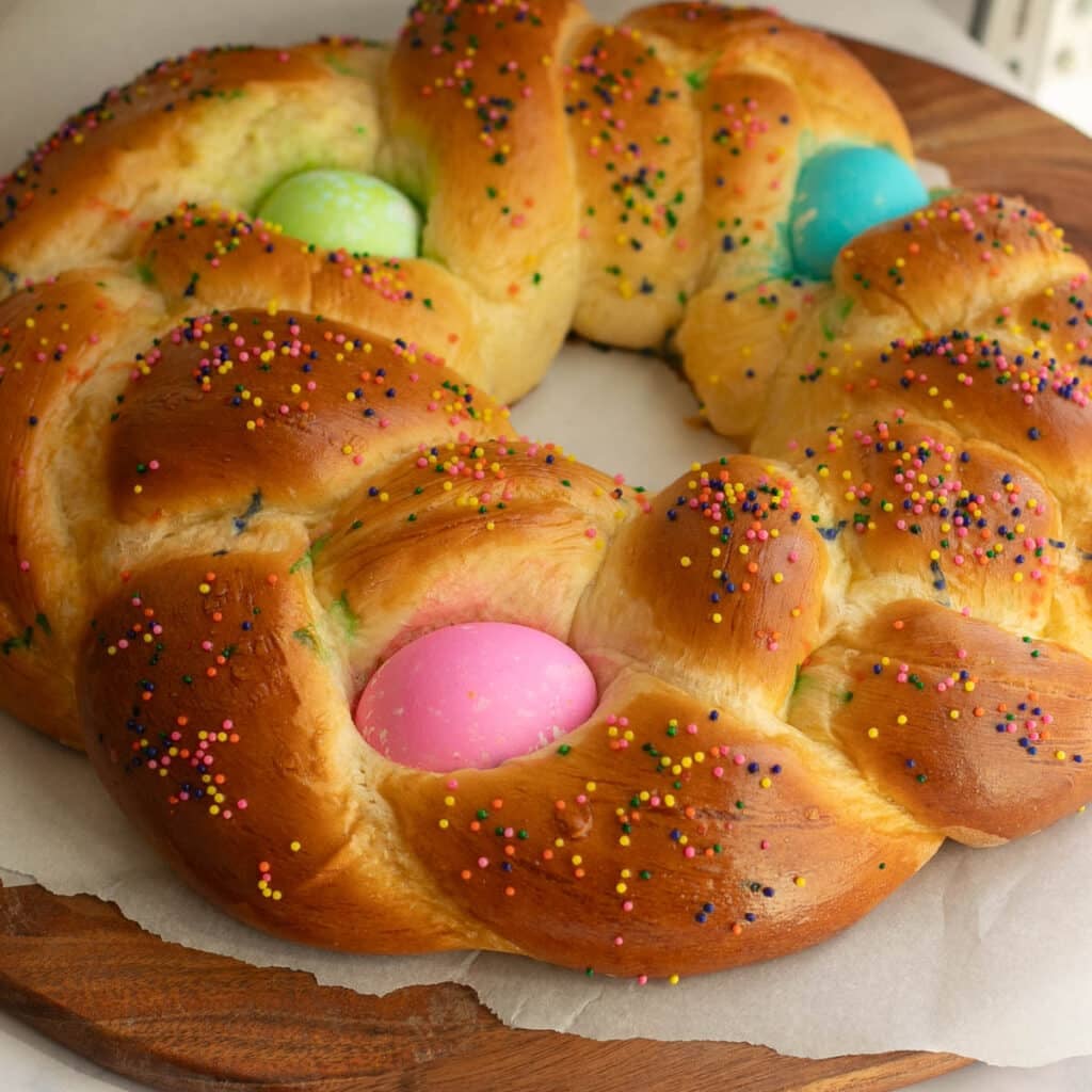 Easter bread in a braided ring topped with colored eggs and sprinkles