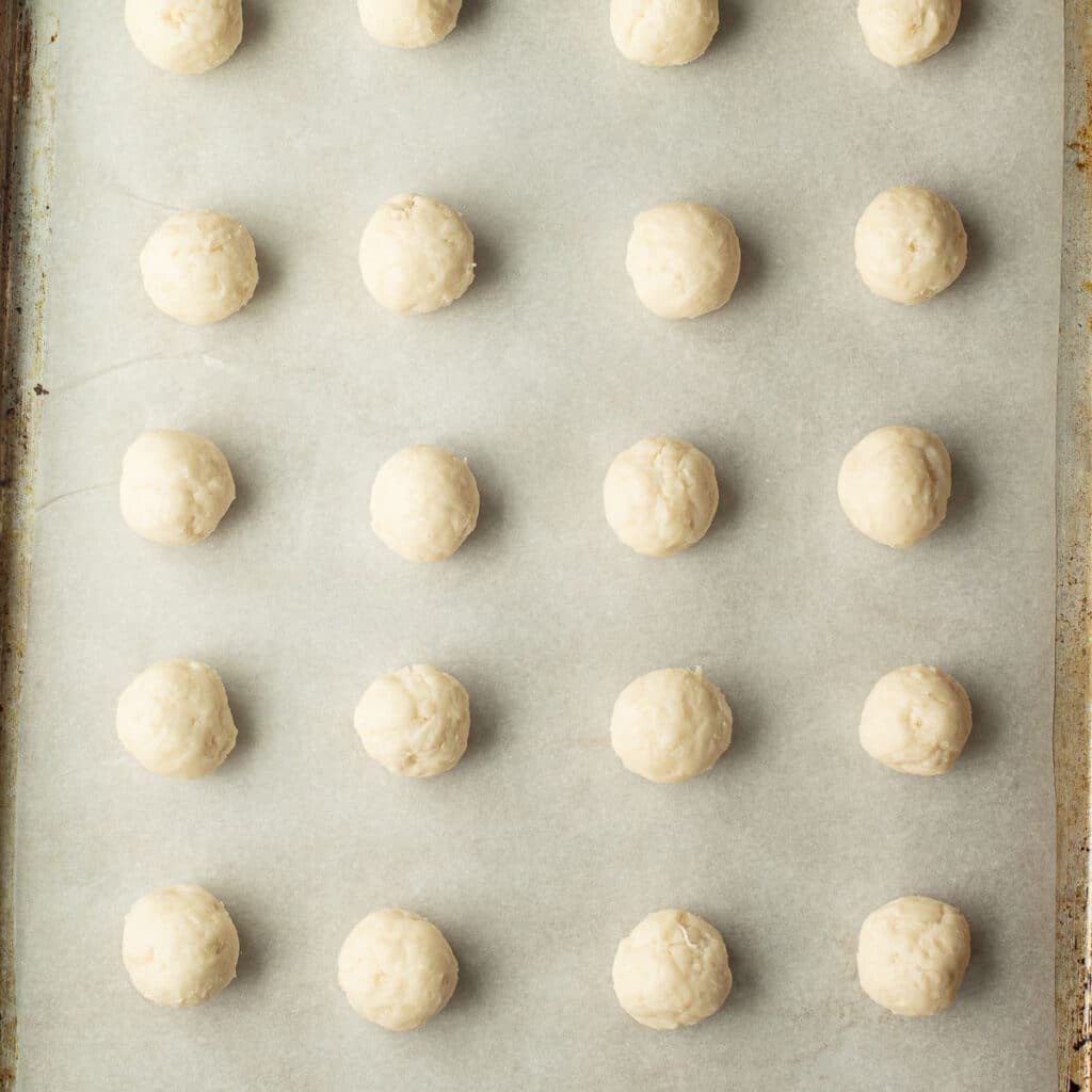 coconut cream fondant rolled into small balls and arranged in rows on a baking sheet
