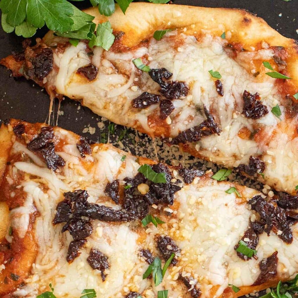 cheese pulling between two pieces of naan pizza