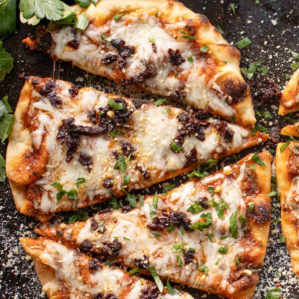 naan pizza cut diagonally into four slices