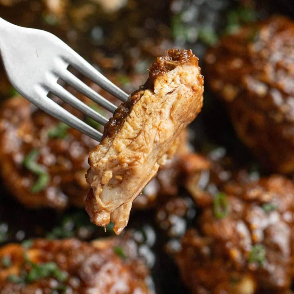a fork holding a piece of honey garlic chicken