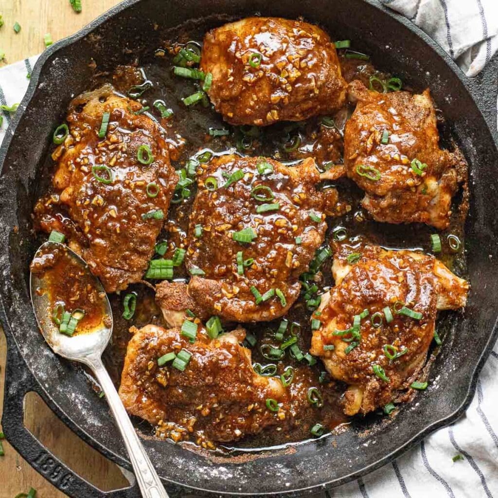 honey garlic chicken thighs in a cast iron pan