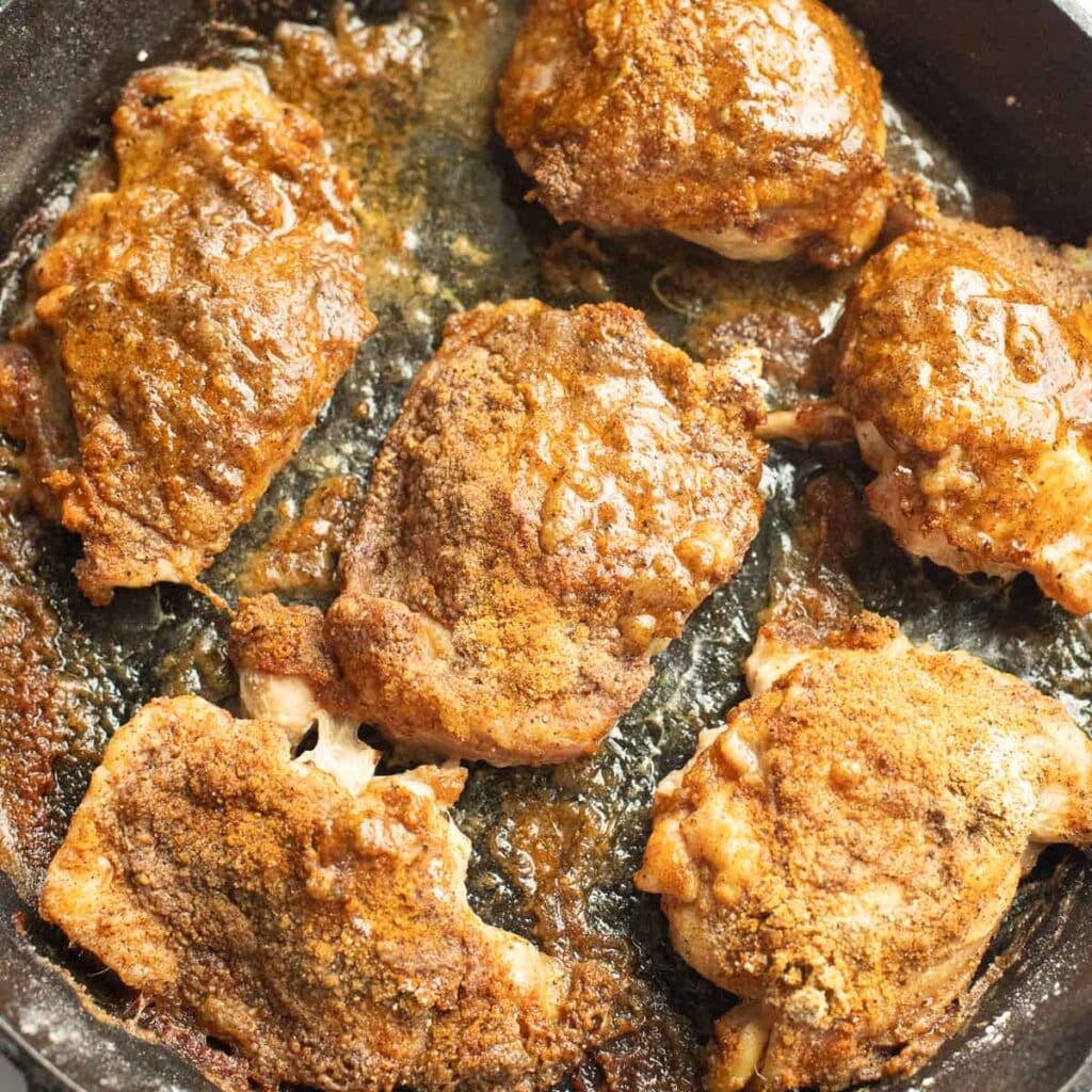 cooked chicken thighs in a cast iron pan