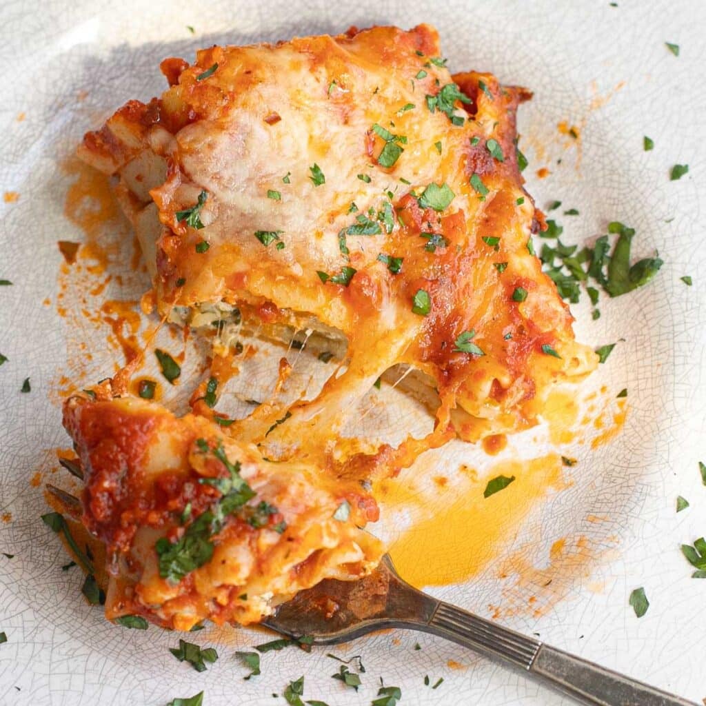 overhead view of lasagna roll ups with a cheese pull