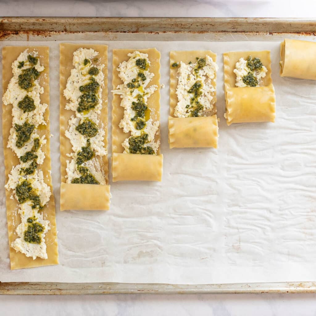 lasagna sheets topped with ricotta cheese and pesto sauce