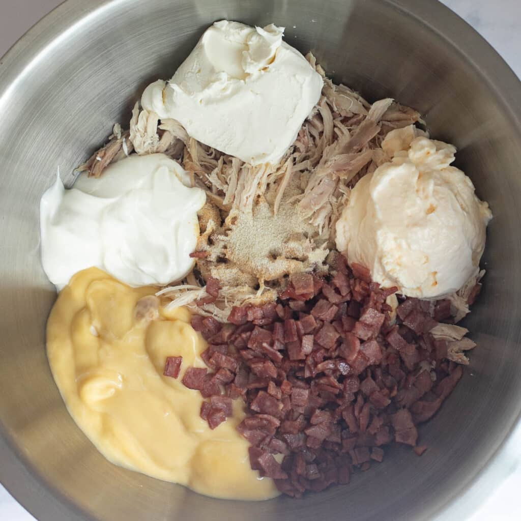 shredded chicken, diced bacon, mayonnaise and sour cream in a mixing bowl