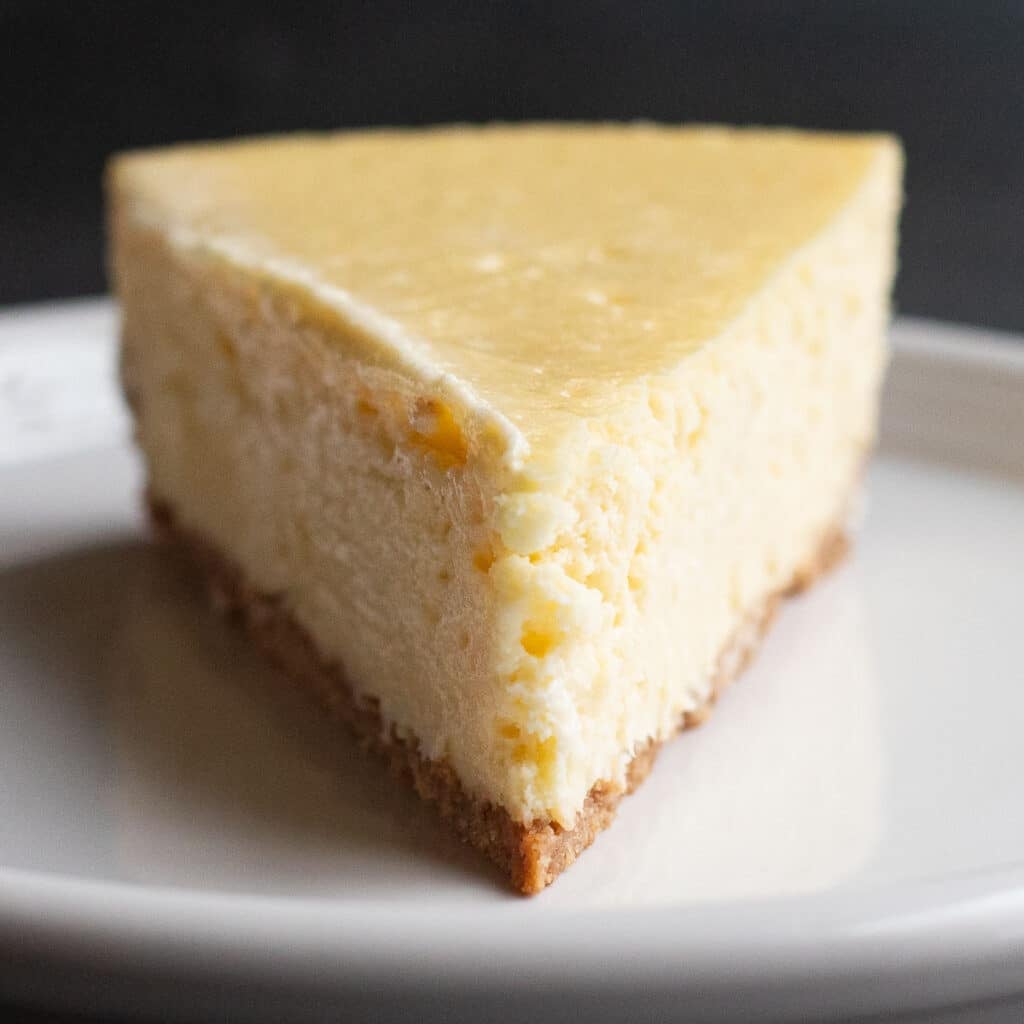plain slice of New York Cheesecake on a white plate