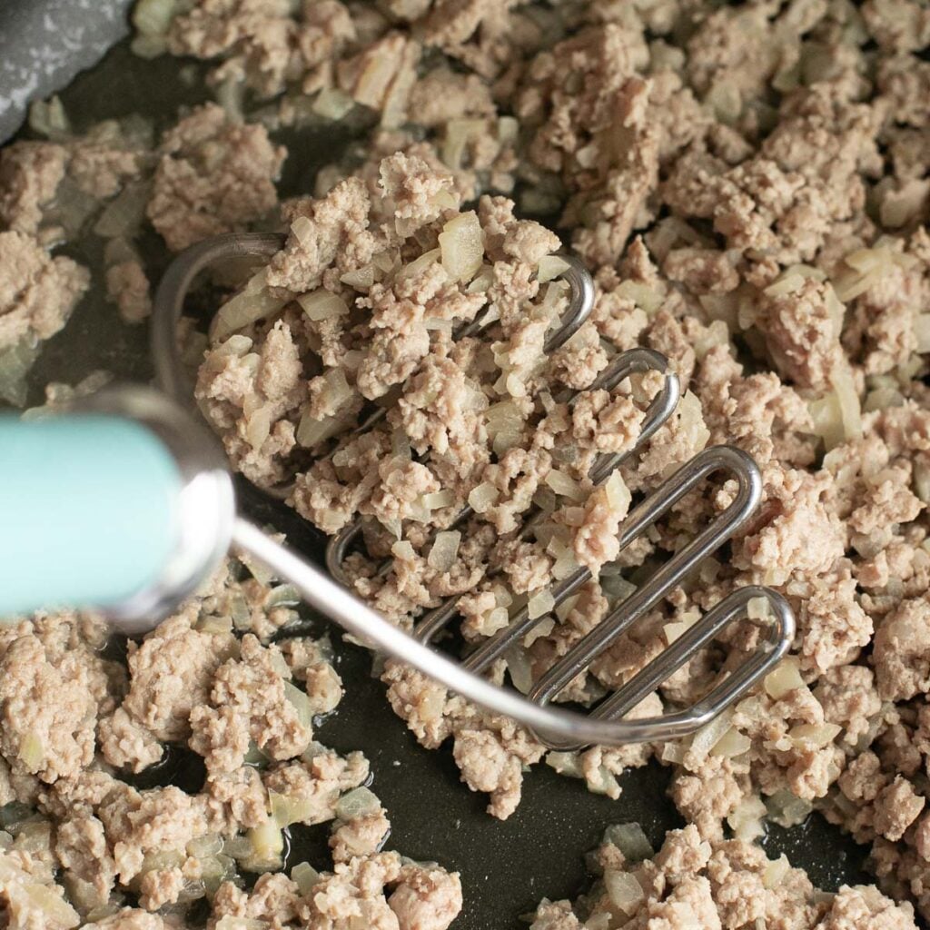 ground turkey and onions cooking in a pan