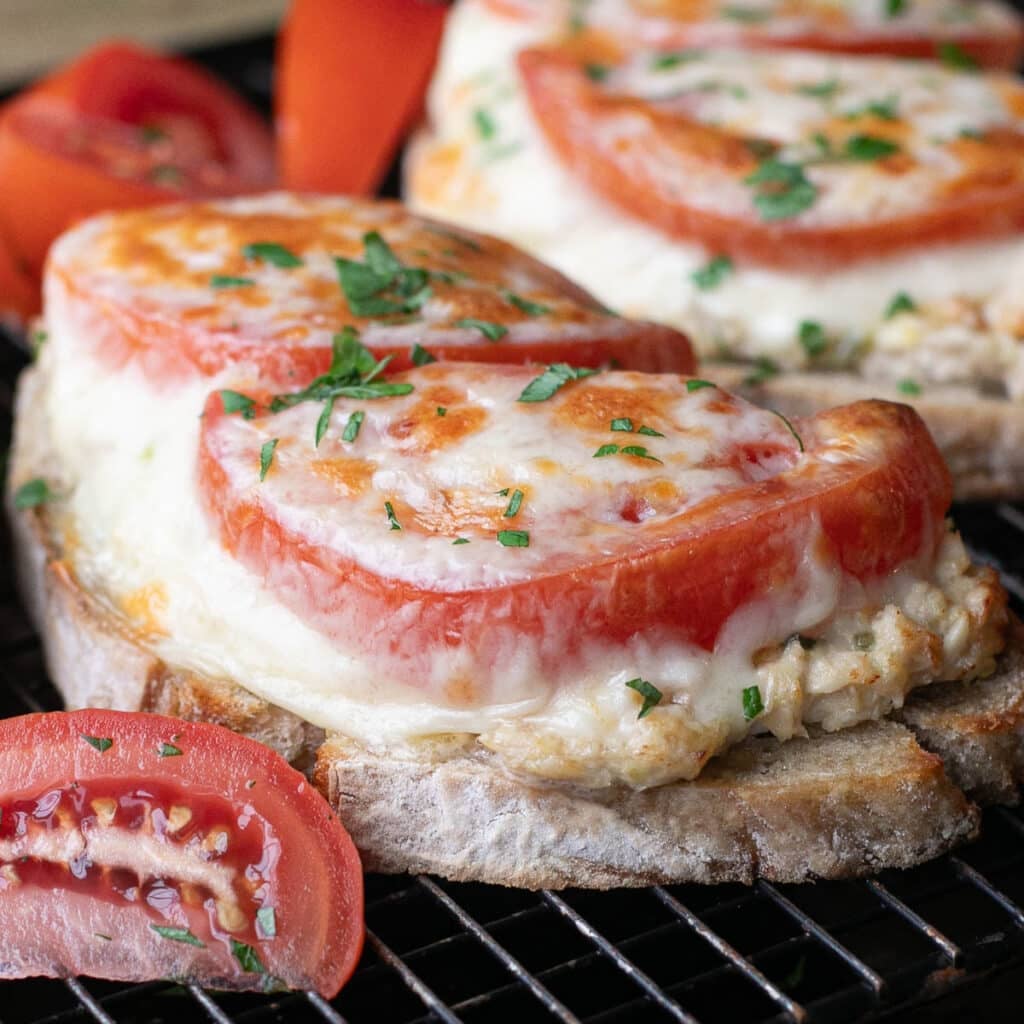 tuna melt sandwich topped with tomato slices and cheese