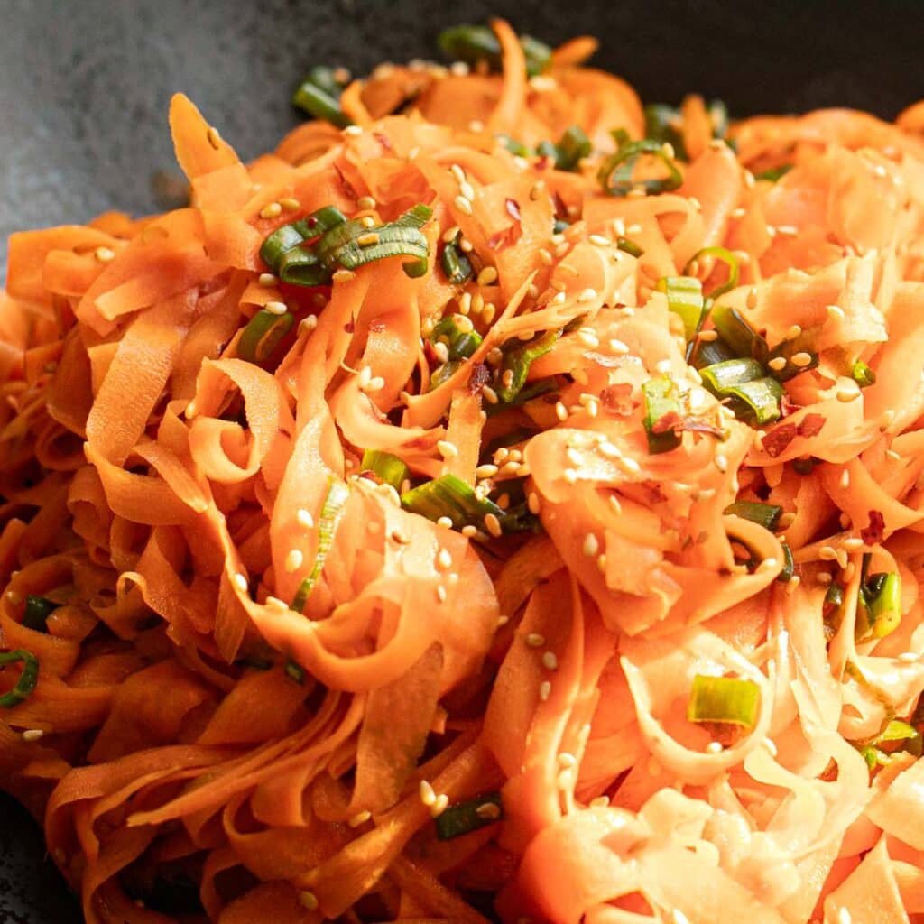 carrot salad topped with scallions and sesame seeds