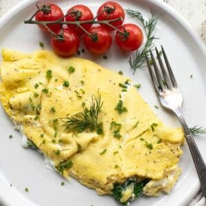 cottage cheese omelet with spinach and tomatoes on a white plate