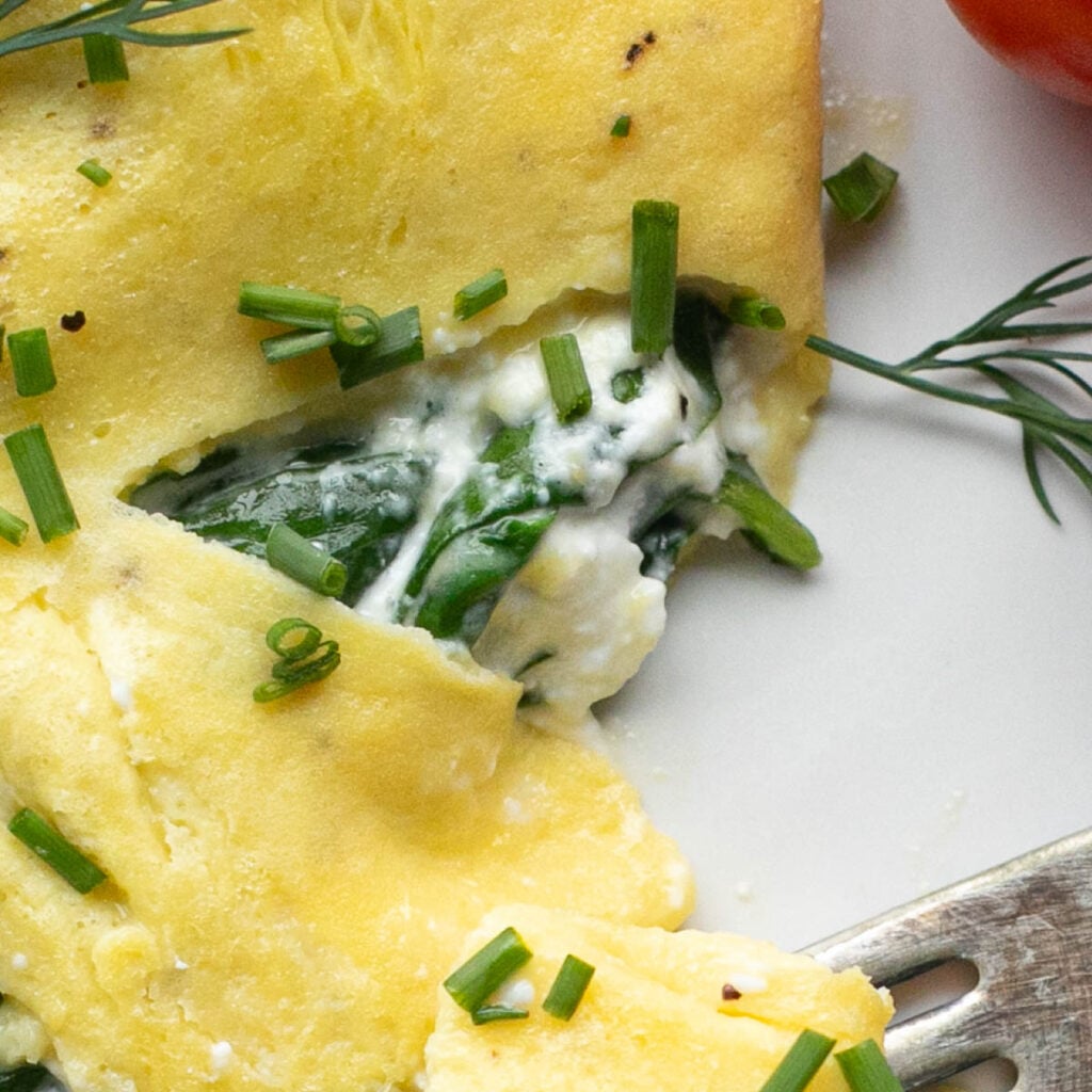 close up view of a cottage cheese omelet with spinach and chives