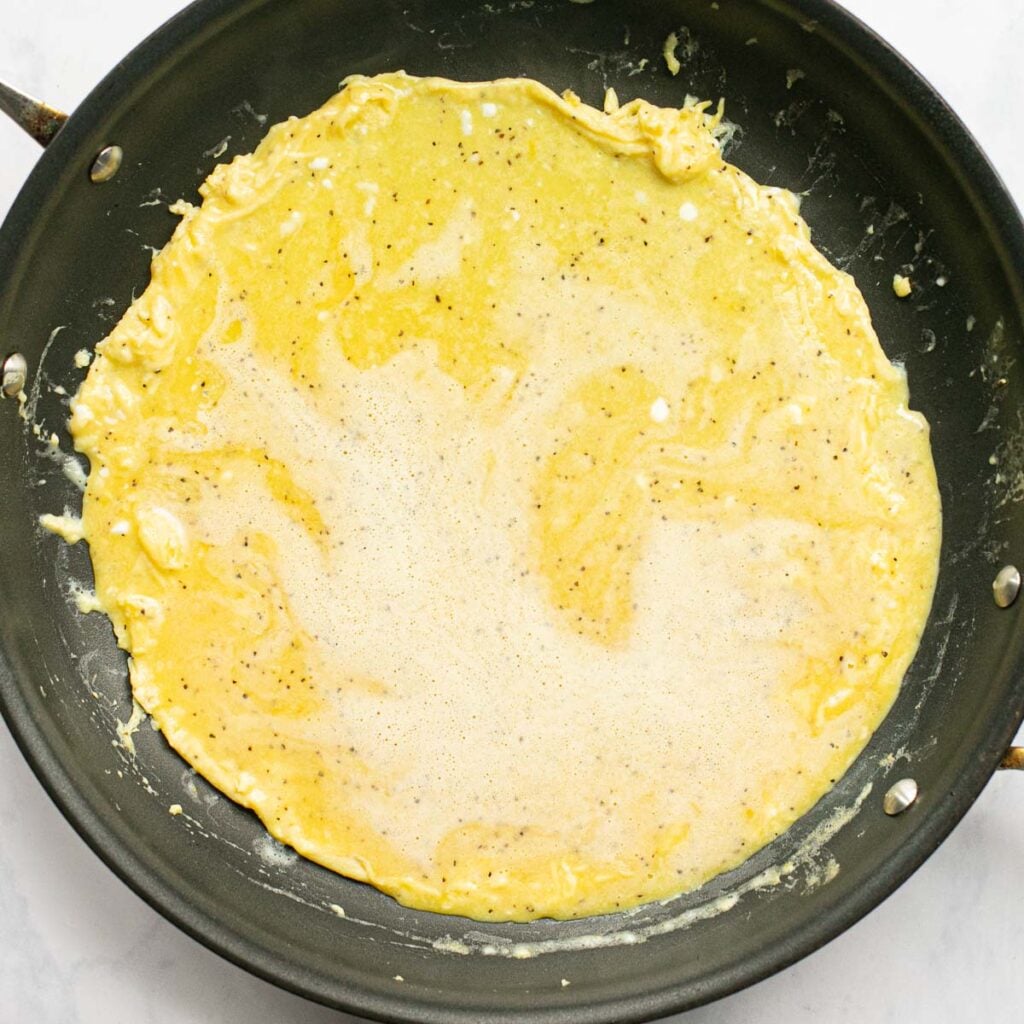 beaten eggs cooking in a pan