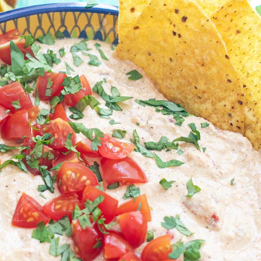 cottage cheese queso topped with diced tomatoes and cilantro