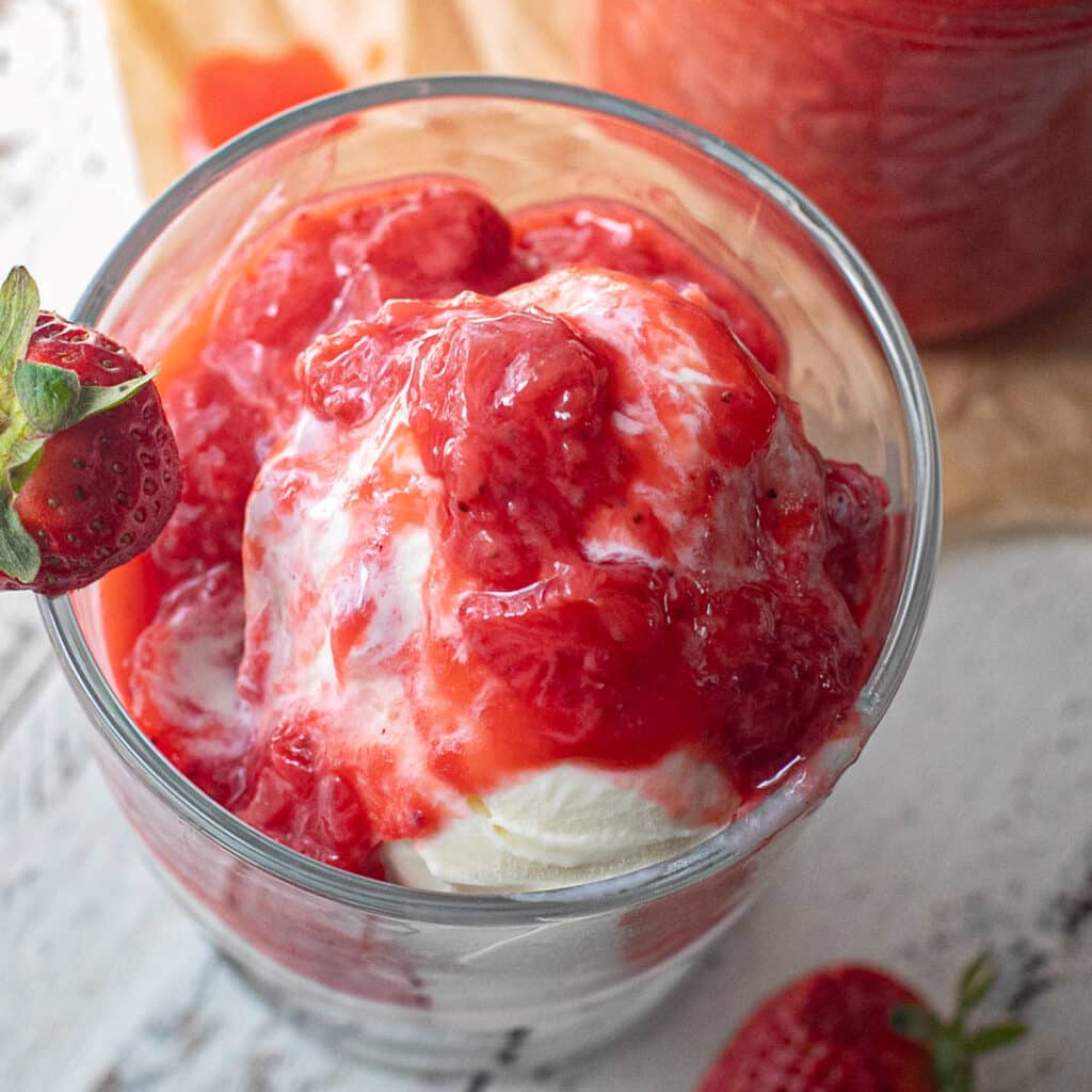 a bowl of vanilla ice cream topped with strawberry sauce
