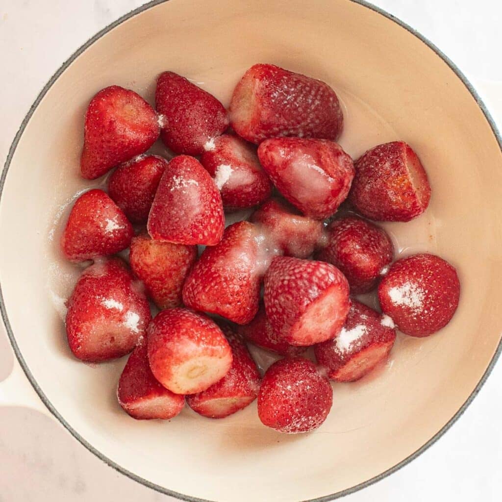 whole strawberries and sugar in a saucepan