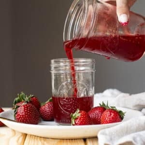strawberry syrup pouring into a mason jar