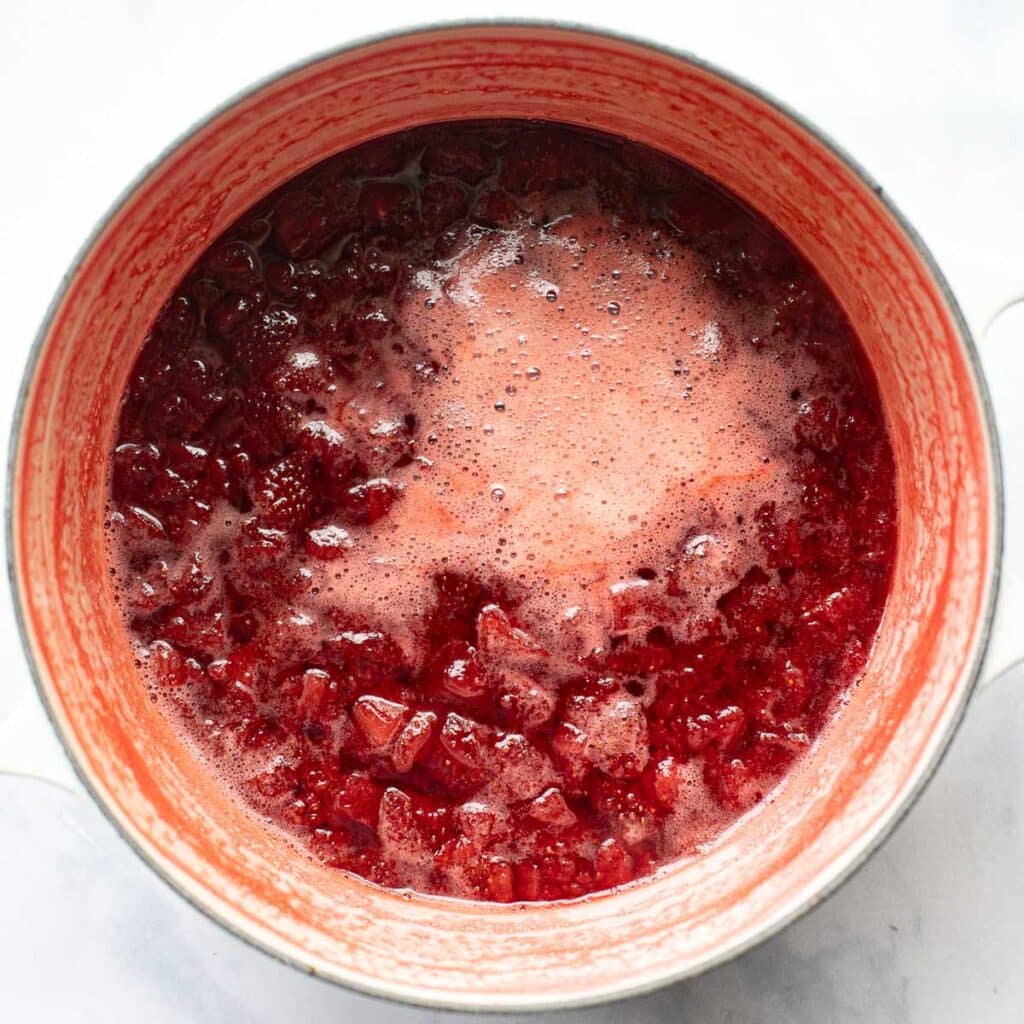 strawberries being cooked down in a saucepan