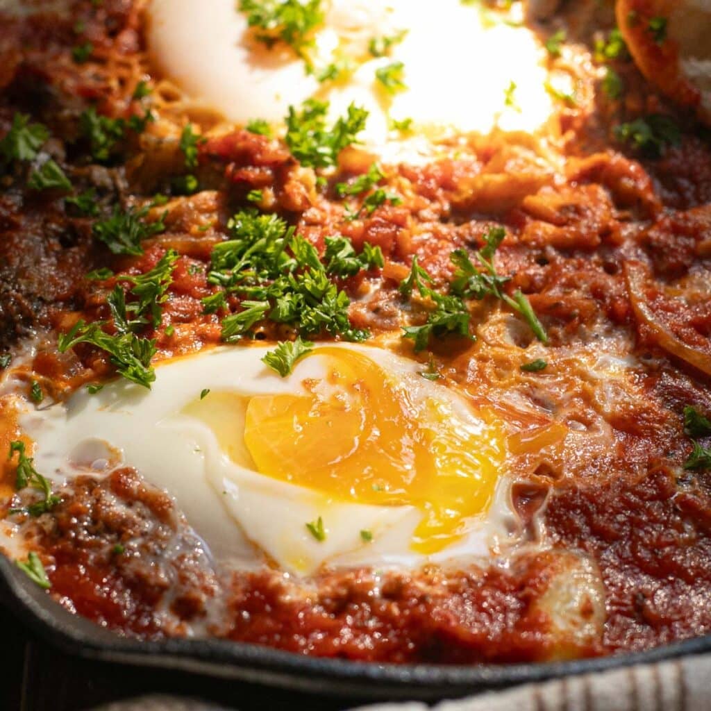 a soft cooked egg in tomato sauce
